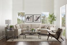 a living room filled with furniture and paintings on the wall next to a wooden floor