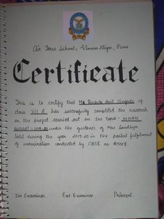 the certificate is written in black ink on a spiral bound book with writing underneath it