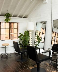 a chair and mirror in a room with wooden floors, white walls and exposed ceilings