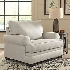 a living room scene with focus on the arm chair and rug in the foreground