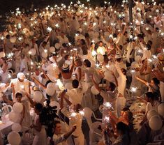 a large group of people holding sparklers in their hands