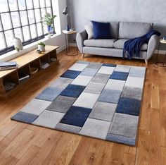 a living room filled with furniture and a rug on top of a hard wood floor