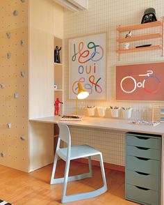 a desk with two chairs and a bike on the wall in a child's room