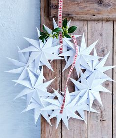 an origami wreath hanging on a wooden door