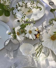 the table is set with flowers and plates