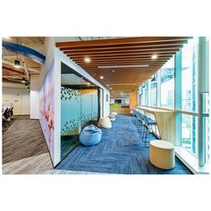 an office with blue carpet and wooden ceiling