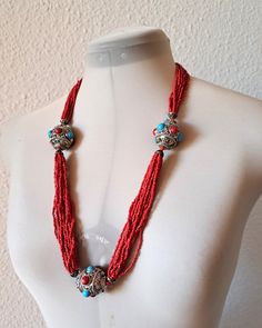 Vintage, probably from the 80s  necklace with multi strands of tiny coral coloured glass seed beads gathered at three points by large /3cm across, approx/ silvery metal hollow beads with turquoise and red glass cabochons  with hook fastener. Very good condition Total length necklace 72 cm/28.4'' Traditional Coral Beaded Necklaces With Colorful Beads, Traditional Turquoise Beaded Necklaces With Spacer Beads, Traditional Turquoise Beaded Necklace With Spacer Beads, Bohemian Red Coral Beaded Necklace With Polished Beads, Traditional Red Coral Beaded Necklace With Colorful Beads, Traditional Coral Necklace With Colorful Beads, Traditional Red Necklace With Tiny Beads, Bohemian Red Beaded Necklace, Red Spiritual Necklace With Tiny Beads