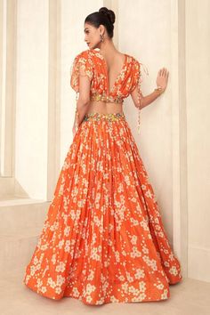 Orange attached cancan lehenga with floral print and a floral applique work waistline. Paired with a floral print blouse with an applique work hem and drawstring details on the shoulder and padded bustier. - Aza Fashions Floral Print Lehenga For Reception And Diwali, Floral Print Traditional Drape Sets For Reception, Navratri Floral Print Lehenga With Traditional Drape, Traditional Drape Choli With Floral Print For Navratri, Traditional Drape Floral Choli For Navratri, Bollywood Style Floral Print Wedding Sets, Festive Floral Print Sets For Reception, Floral Print Sharara For Reception And Navratri, Floor-length Floral Print Choli For Diwali