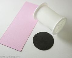 a pink and black piece of paper next to a white cup