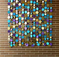 a brick wall with blue, purple and gold circles hanging from it's sides