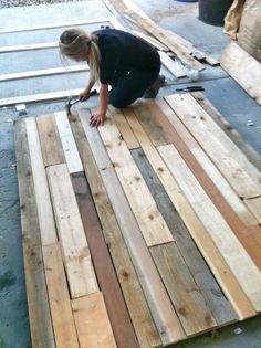 a woman is working on some wood planks