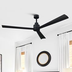 a black ceiling fan in a white bedroom