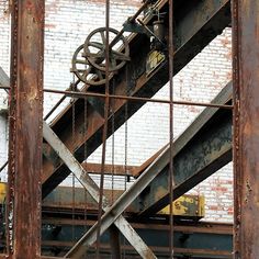 an old rusted metal stair case in front of a brick wall