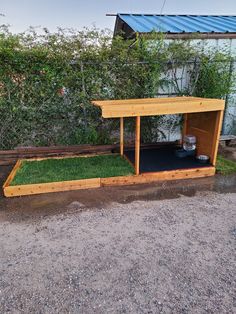 an outdoor dog house with grass in it