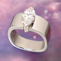 a white gold ring with a diamond in the center on a purple and pink background