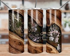 three stainless steel tumblers with wood designs on them