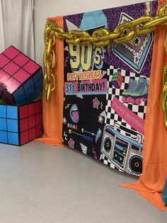 a birthday party backdrop with rubik cubes and chains