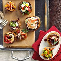 an assortment of appetizers are served on trays with forks and napkins