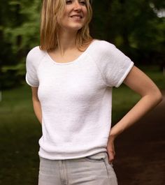 a woman is standing in the grass with her hands on her hips and looking at the camera