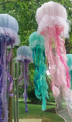 jellyfish decorations are hanging from poles in the park