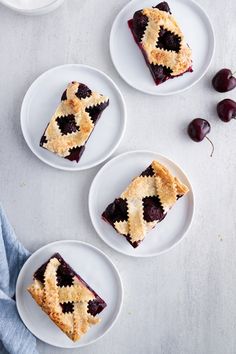 three white plates topped with slices of cherry pie