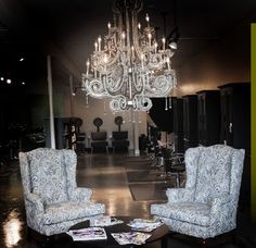 two chairs and a coffee table in a room with chandelier