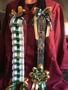 a person wearing a graduation gown and holding two ribbons with money on them, in front of him