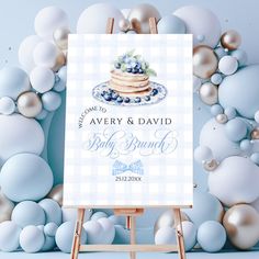 a blue and white wedding sign on an easel with balloons in the back ground