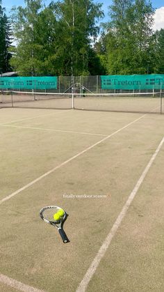 a tennis court with a racket and ball on the ground in front of it