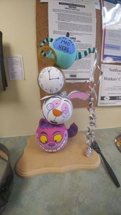 an office desk with a clock, mouse and paperweights on top of it