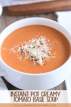 a white bowl filled with tomato soup and topped with parmesan cheese