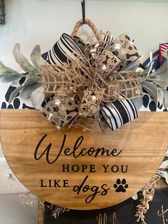 a welcome sign hanging from the side of a wooden plaque that says, welcome hope you like dogs