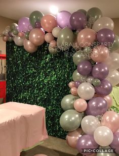 balloons and greenery decorate the backdrop for an event