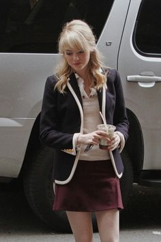 a woman walking down the street holding a cup