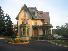 an old victorian style house with a fountain in the front yard