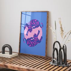 an art print is displayed on a shelf next to two vases and a plant