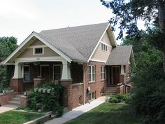 a small brick house sitting on the side of a road