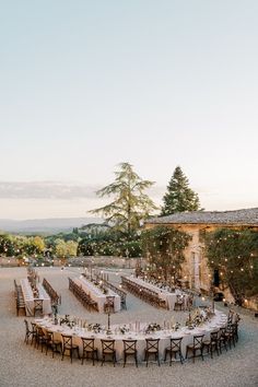 an outdoor wedding reception setup with tables and chairs set up in the middle of it