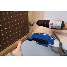 a person is using a drill to fix a cabinet door