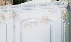 a white cabinet with starfish decorations on it