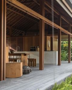 an outdoor kitchen and dining area in a wooden structure with wood flooring on the outside