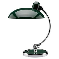 a green desk lamp sitting on top of a white table