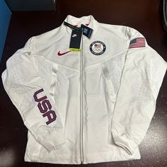 Nike Mens White Ck4552-100 Team Usa Medal Stand Windrunner Full Zip Jacket Sz Xs Brand: Nike Department: Men Size: Xs Color: White Type: Jacket Style: Windbreaker Pattern: Solid Theme: Usa Neckline: Collared Occasion: Activewear Season: Fall, Winter Features: Full Zip, Pockets Sleeve Length: Long Sleeve Condition: New With Tags I Offer Discounts For All Return Customers. - Jvs White Hooded Windbreaker For Running, White Track Jacket For Sports Season, White Track Jacket For Outdoor Sports Season, White Sports Outerwear, White Sportswear Windbreaker For Running, White Long Sleeve Track Jacket For Running, Nike Functional Outerwear For Sports Events, White Sports Windbreaker, White Sportswear Outerwear For Running