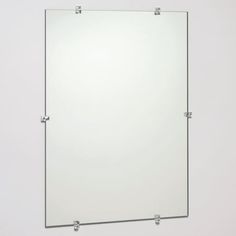 a white wall mounted mirror on the side of a bathroom wall with metal fittings