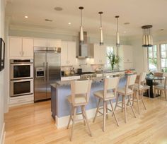 a kitchen with an island and chairs in it