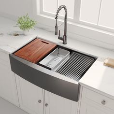 a stainless steel kitchen sink with wooden cutting board in the bottom drawer and faucet