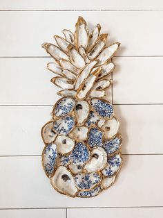 a blue and white pineapple is hanging on the wall