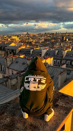 a person sitting on top of a roof looking at the city