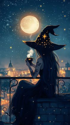 a woman in a witches hat sitting on top of a building at night with a cup of coffee