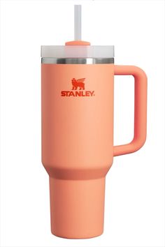 an orange travel mug with a straw sticking out of the cup and stanley logo on it